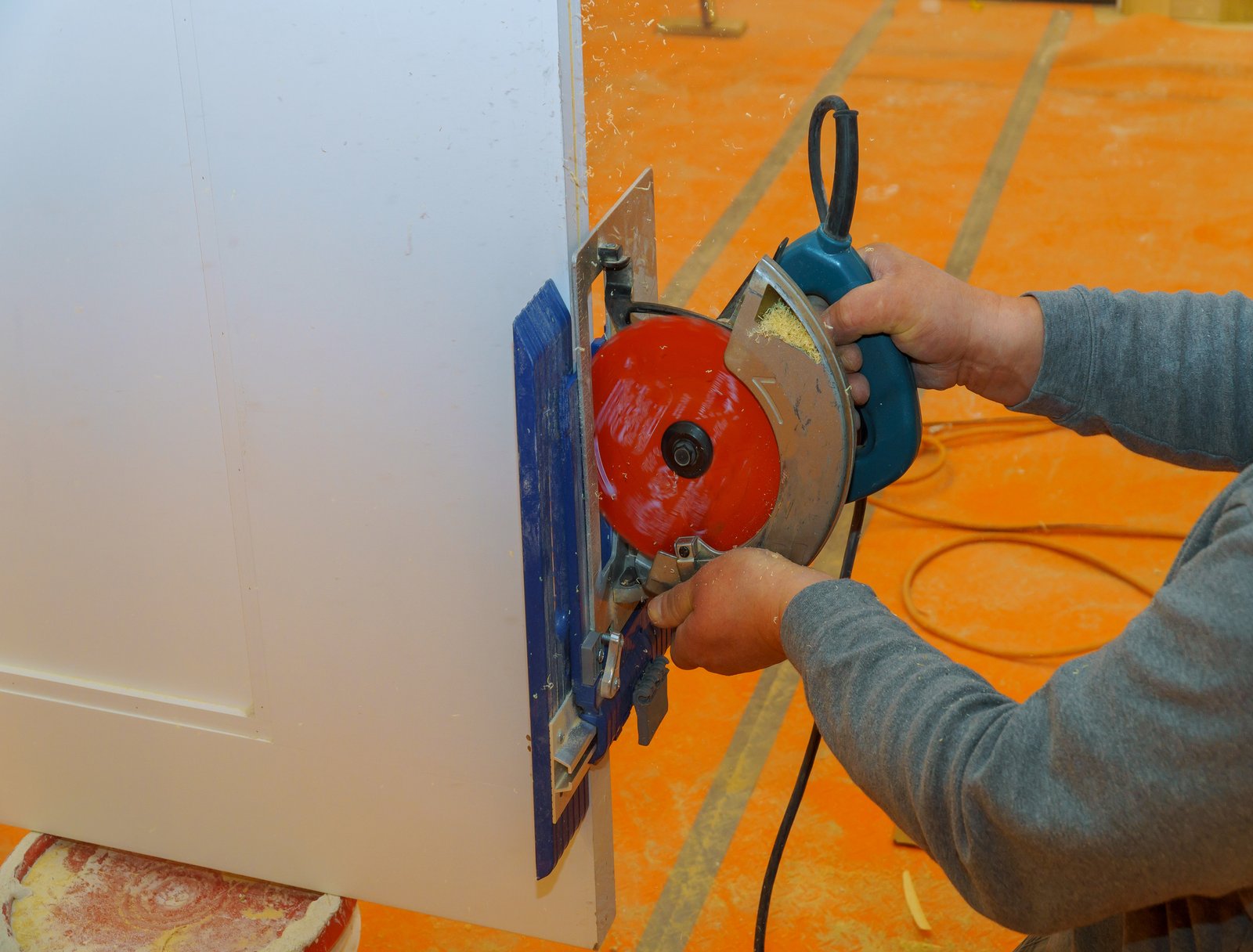 Contractor using electric saw to cut door and door trim boards on the construction of a new home