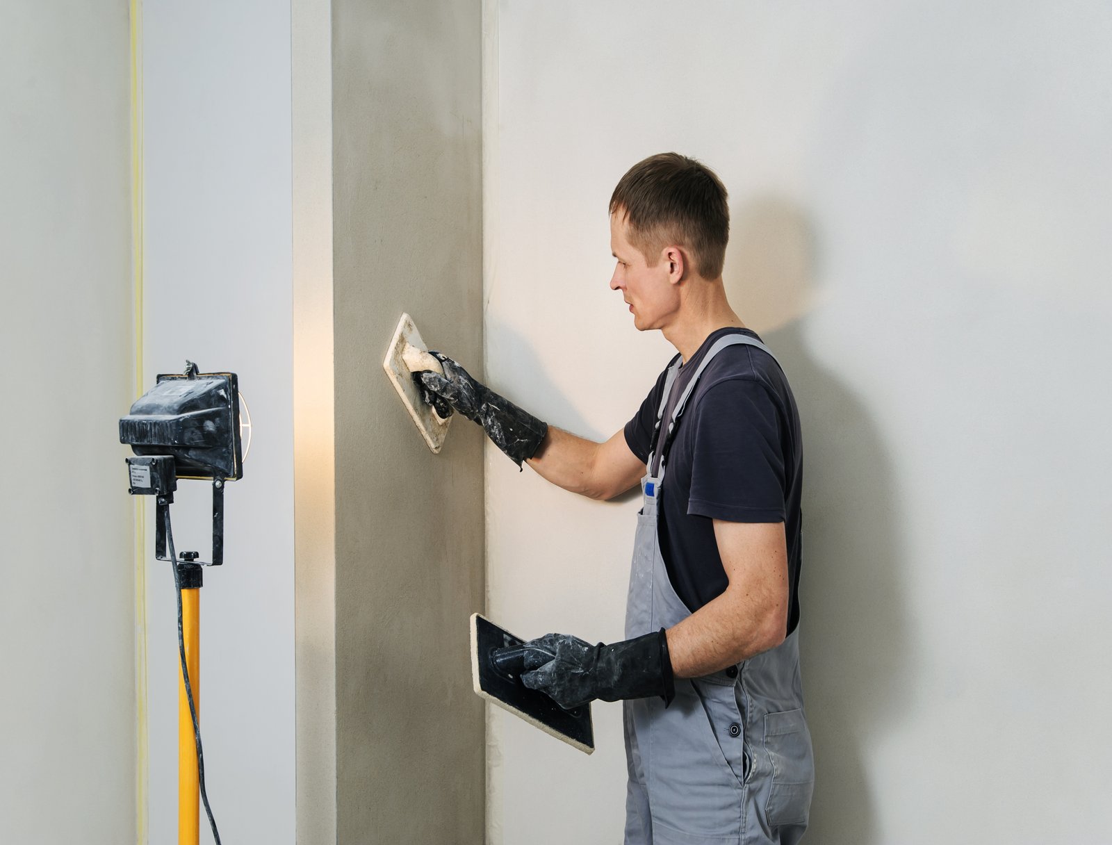Worker makes final smoothing plaster on the wall using a plastic and Felt floats.
