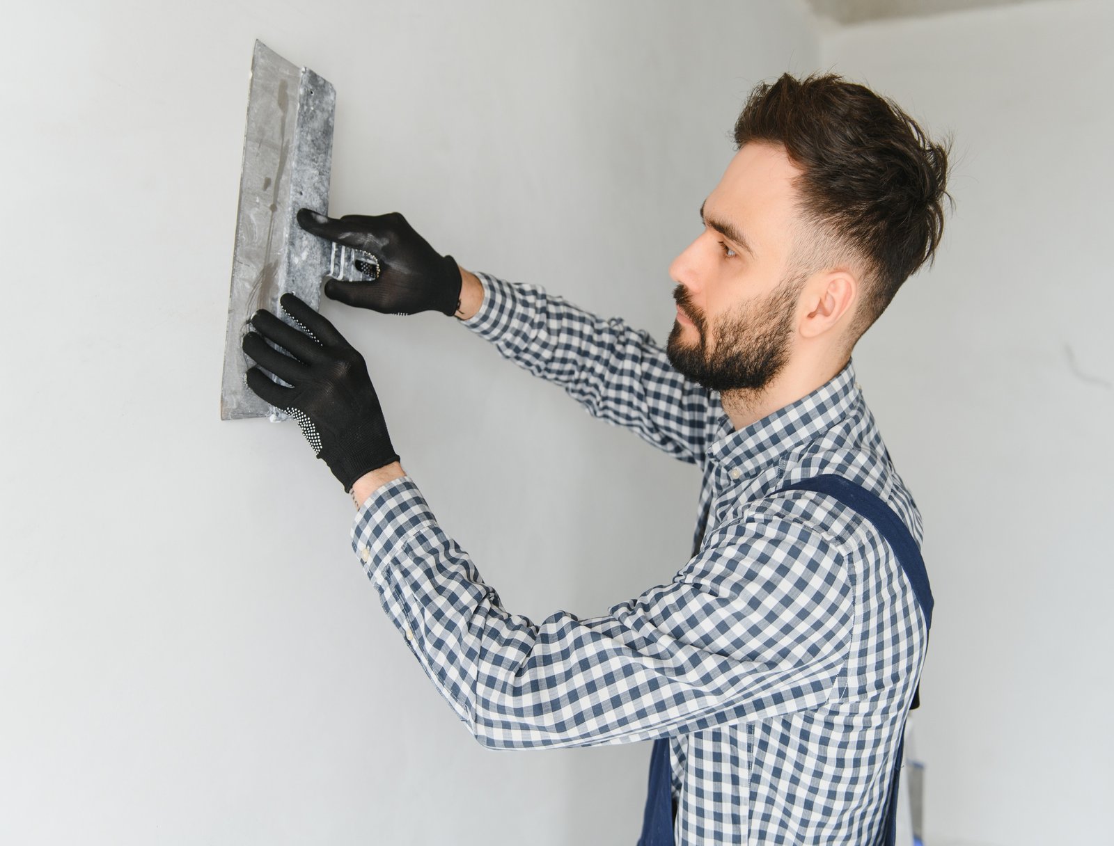 Young worker making repair in room.
